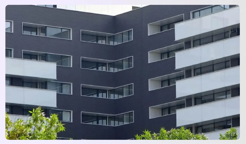 A modern apartment building with dark facadeย A modern apartment building with dark facadeย