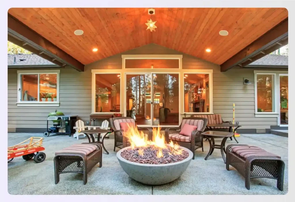 Covered porch featuring a stone fire pit