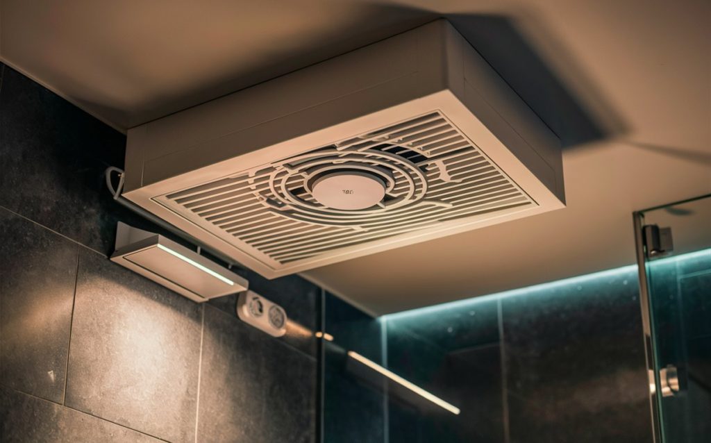 A close-up of a motion-sensored exhaust fan in a bathroom ceiling.