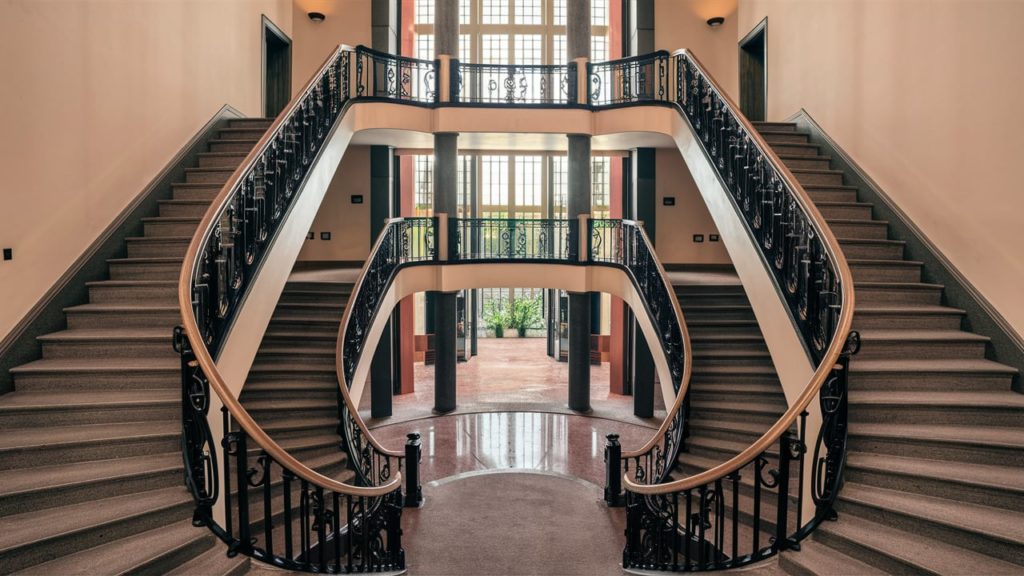 Symmetrical U-shaped staircase with marble floors