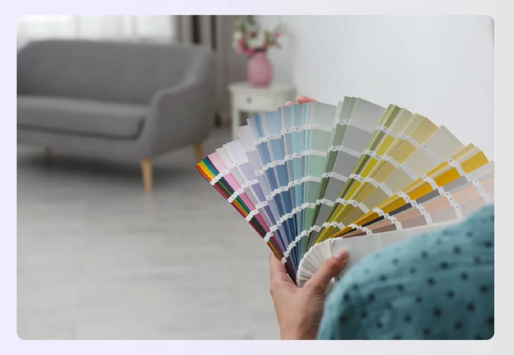 A person holding a fan of color paint swatches