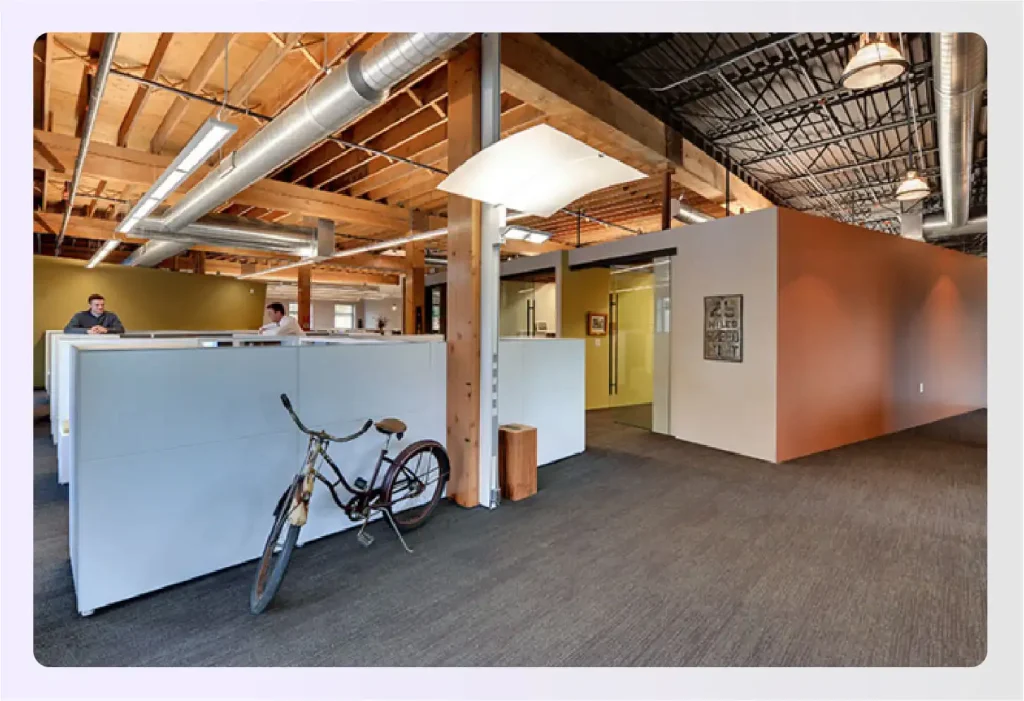 Modern office space with exposed beams and workstations 