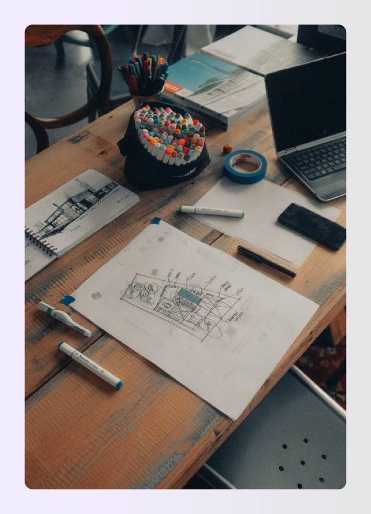 Open sketchbooks with markers on a wooden desk Open sketchbooks with markers on a wooden desk