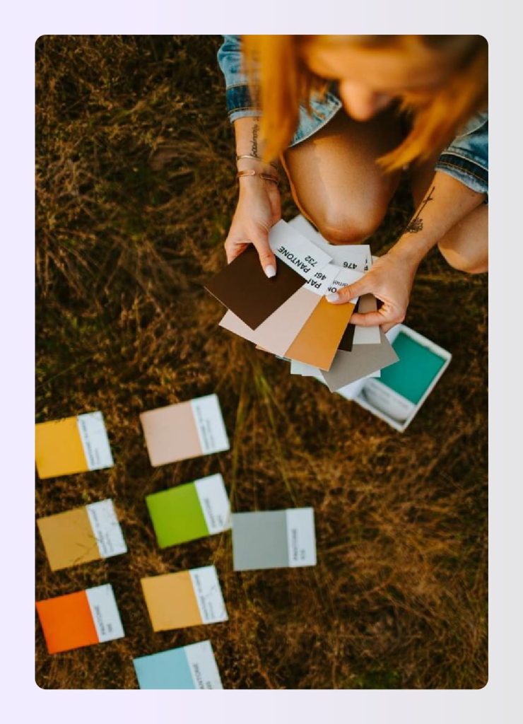 Woman holding various Pantone color cards outdoors