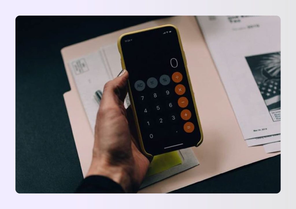 Hand holding smartphone with calculator app open