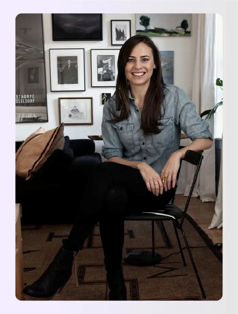 Ariel Ashe smiling while sitting on a black chairย Ariel Ashe smiling while sitting on a black chairย