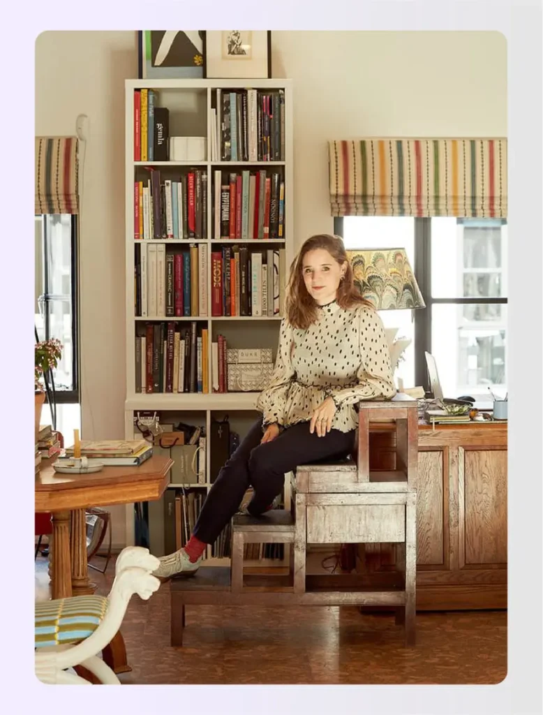 Beata Heuman sitting in a colorful library spaceย Beata Heuman sitting in a colorful library spaceย