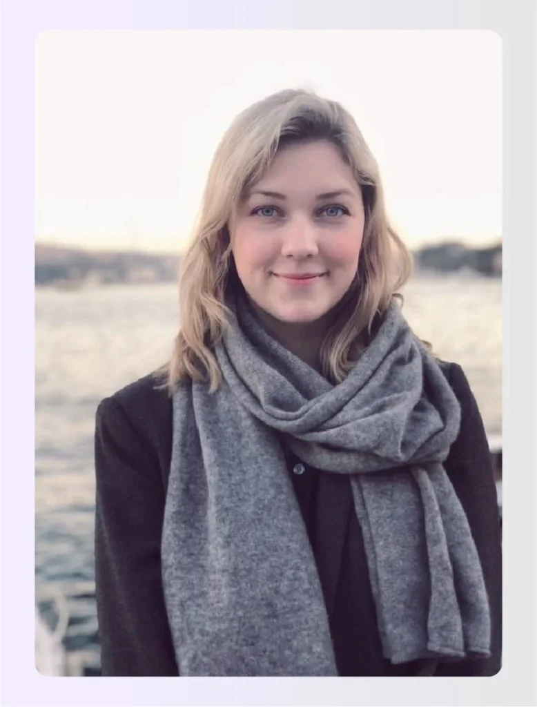 Henriette Kockum smiling wearing a grey scarfย Henriette Kockum smiling wearing a grey scarfย