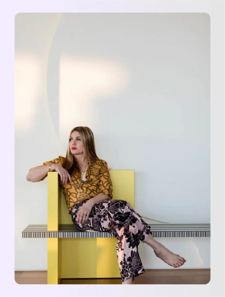 Kelly Behun posing on a modern yellow geometric bench Kelly Behun posing on a modern yellow geometric bench