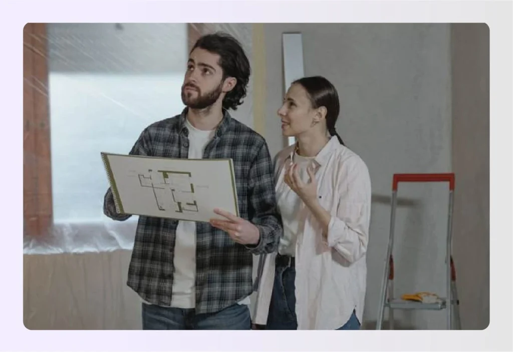 Two people looking at a house plan renovationย Two people looking at a house plan renovationย
