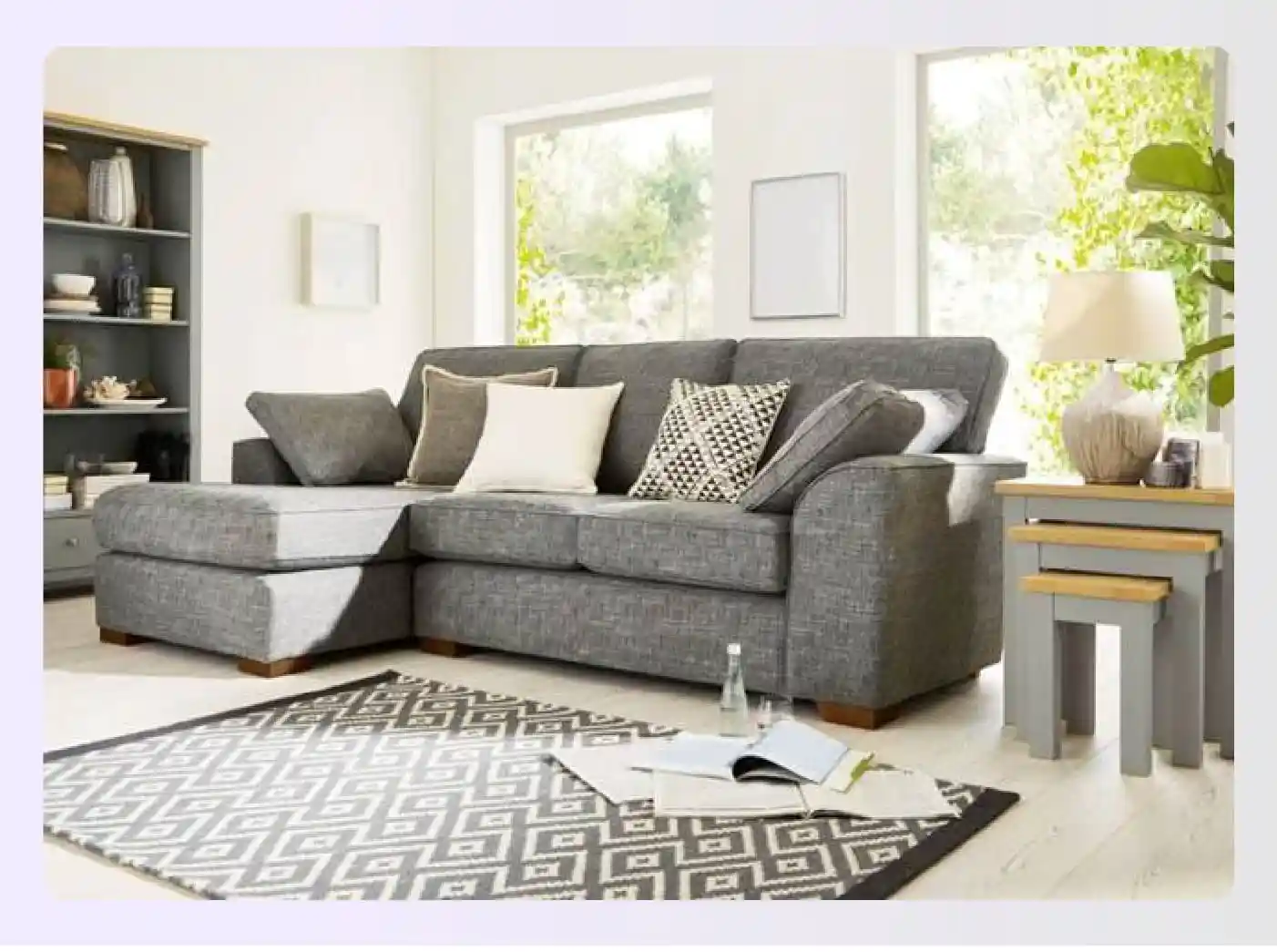Grey sofa with textured cushions and geometric rug in a living room Grey sofa with textured cushions and geometric rug in a living room