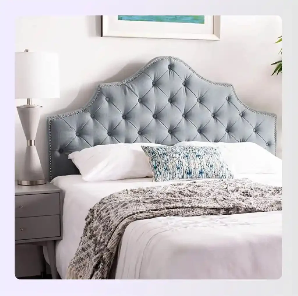 Blue tufted headboard with silver nailhead trim in a bedroom Blue tufted headboard with silver nailhead trim in a bedroom