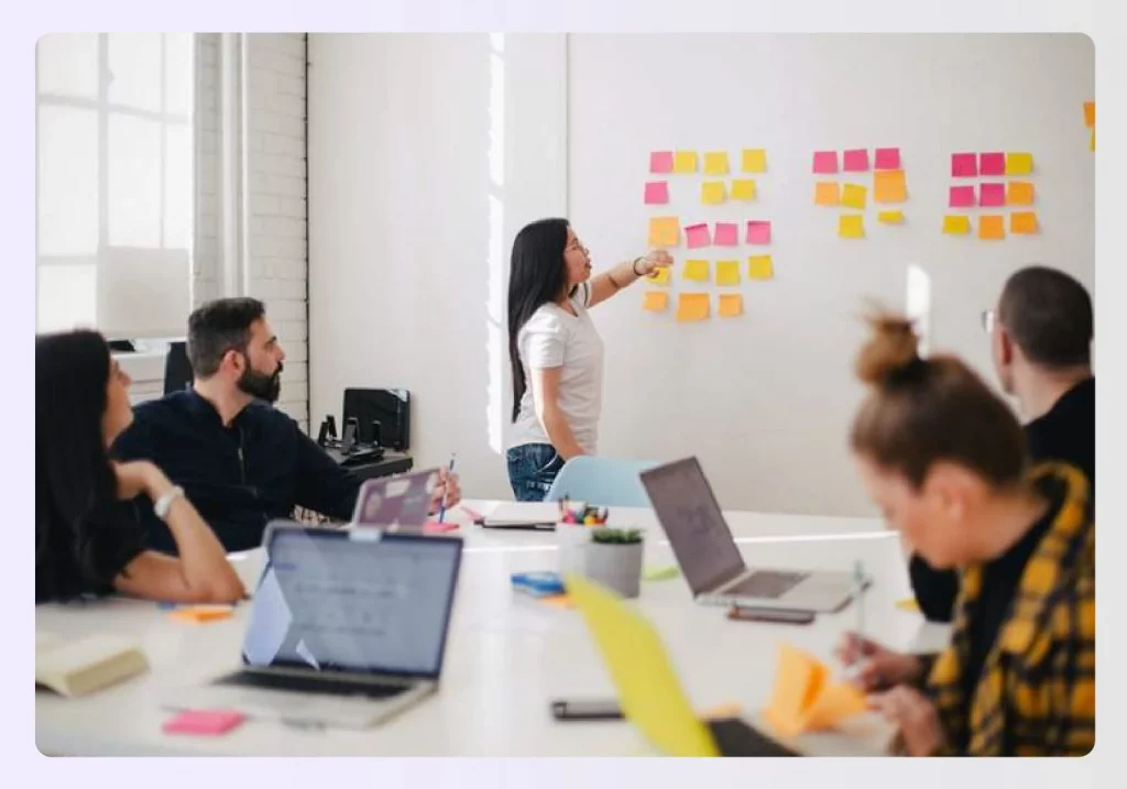 Team members collaborating and optimizing a project on a whiteboard