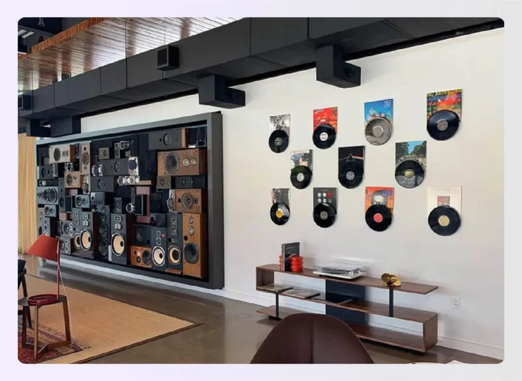 Wall decorated with vinyl records and a large speaker array