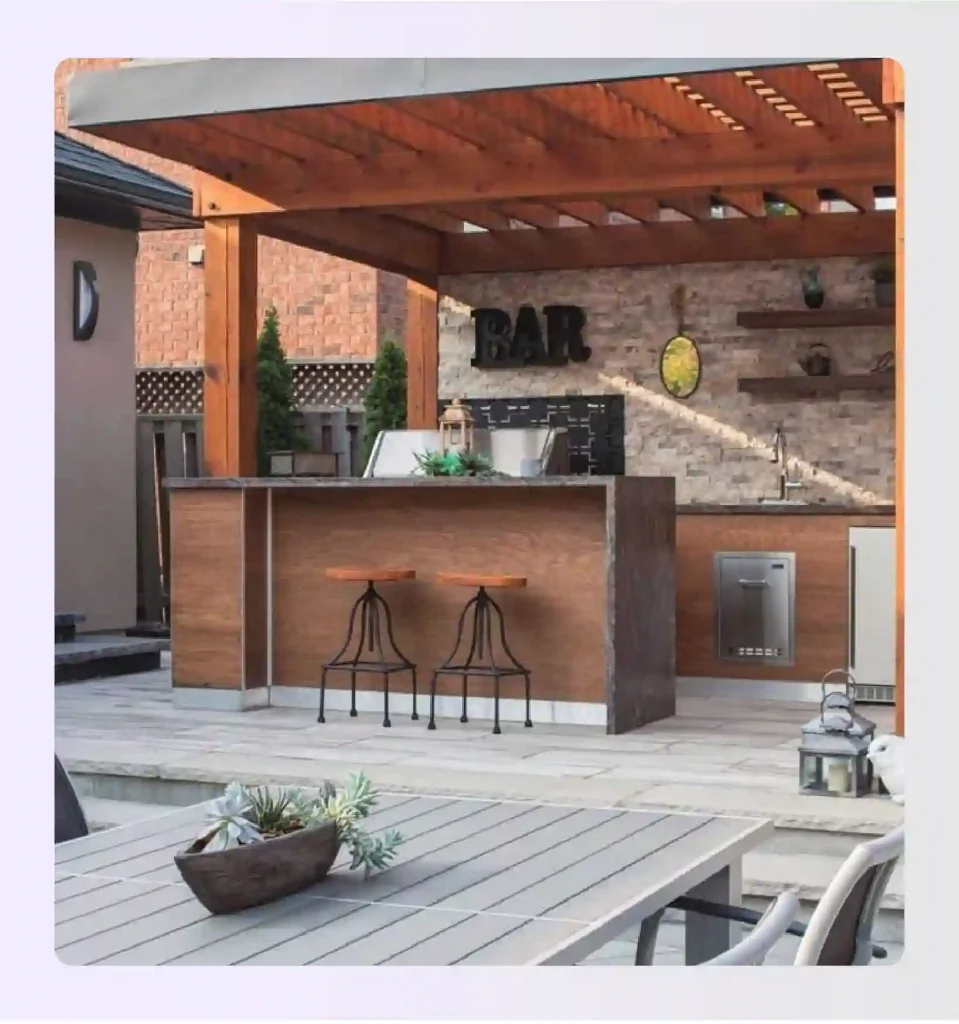 Large stone kitchen island with bar seating under a wooden pergola Large stone kitchen island with bar seating under a wooden pergola