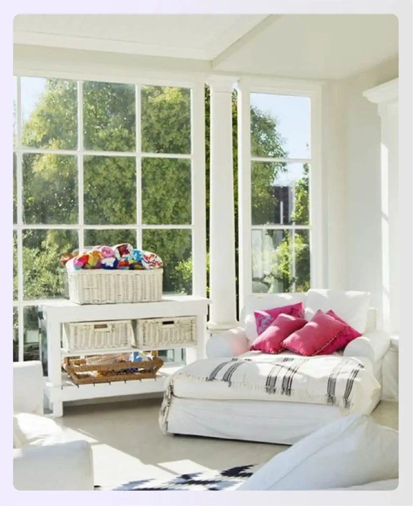 Bright white sunroom with pink pillows
