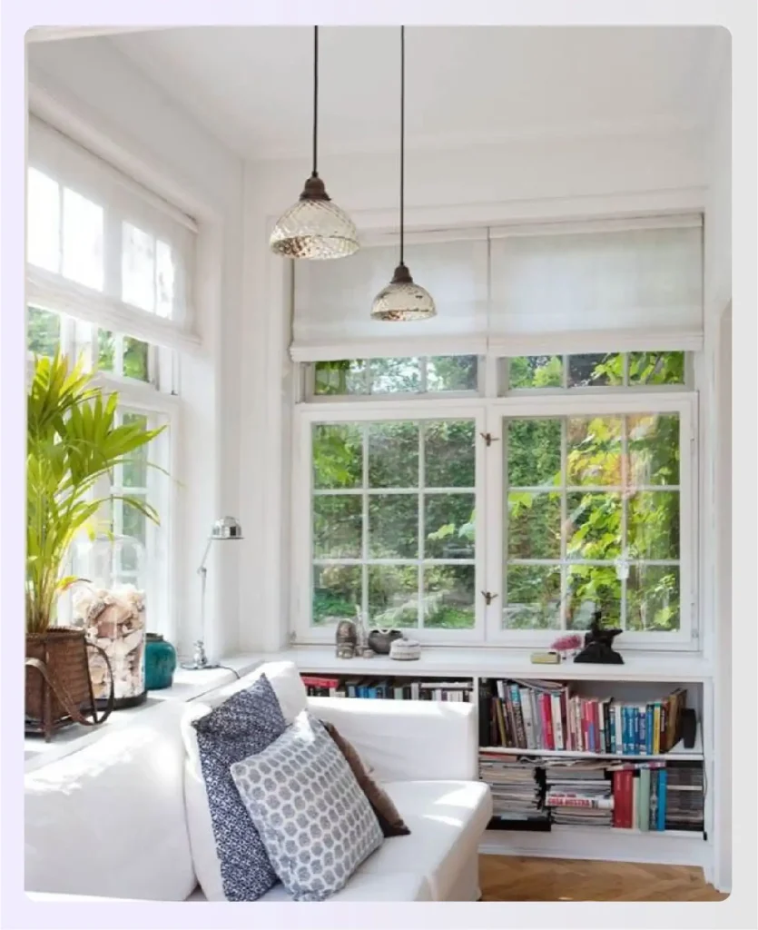 Sunroom reading nook with white sofa and books