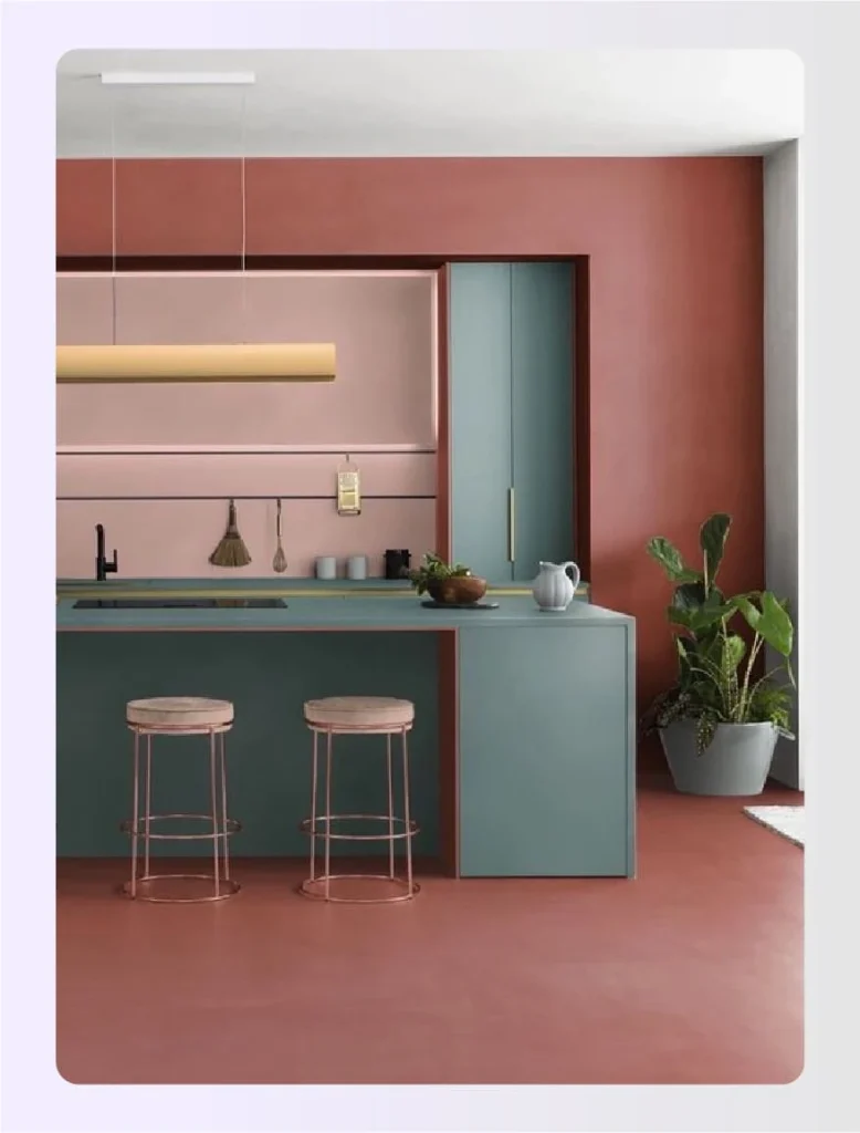 Color blocked kitchen with pink walls and teal island 