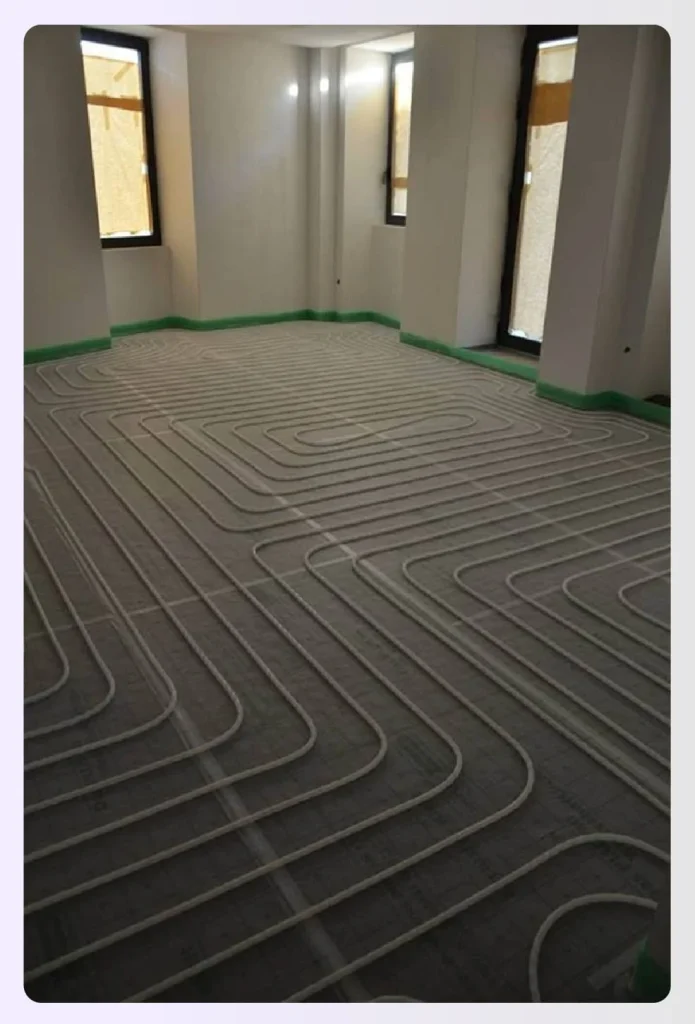 Wet underfloor heating pipes laid before flooring installation