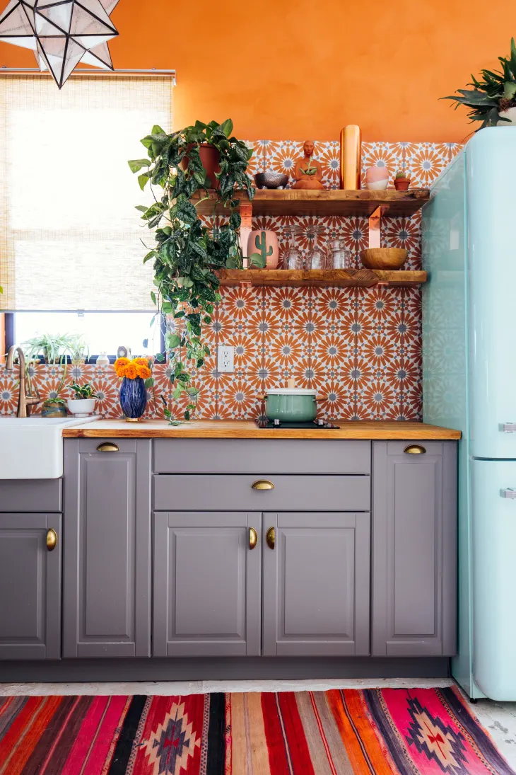 https://foyr.com/learn/wp-content/uploads/2022/12/dark-grey-with-orange-kitchen-color-schemes.webp