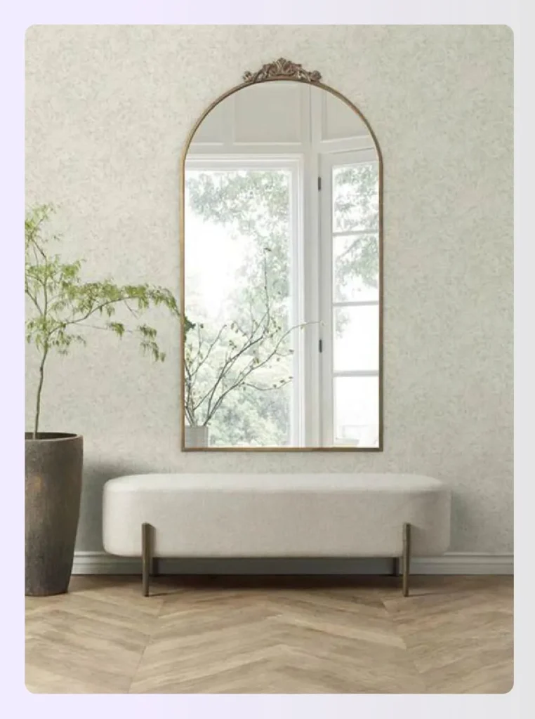 Gold framed arched mirror on a textured wall Gold framed arched mirror on a textured wall