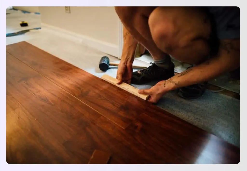 Person installing laminate wood-look floor planks