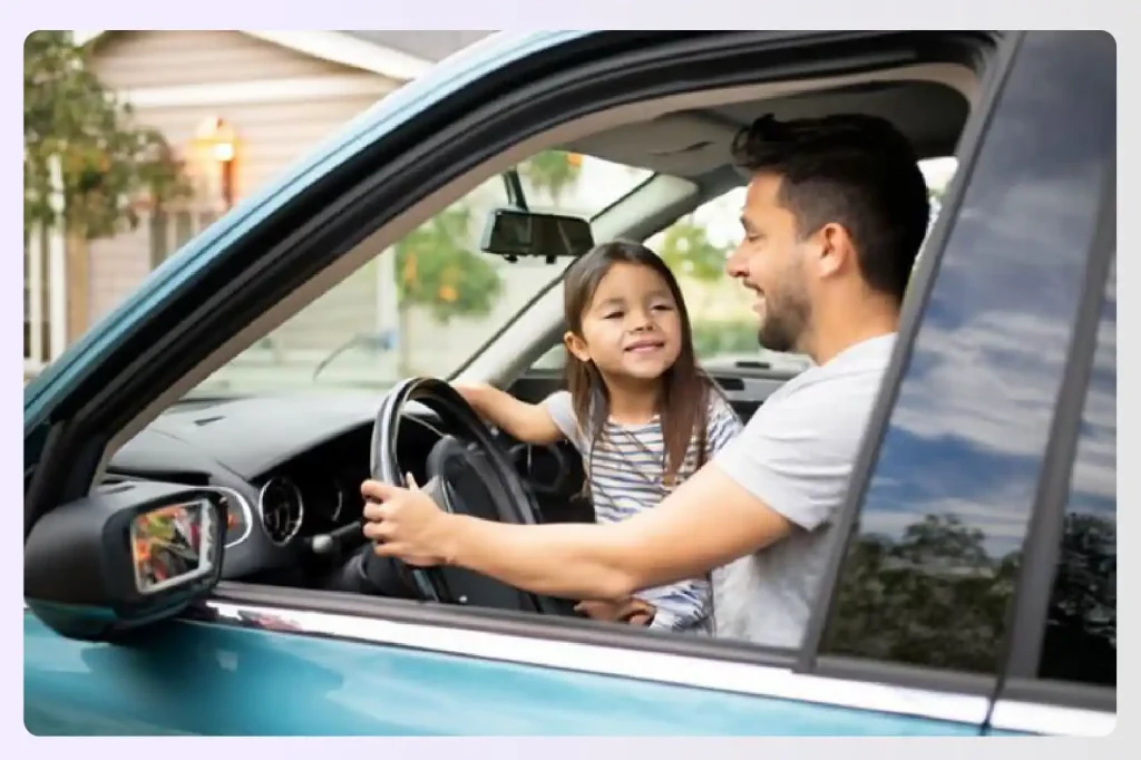 A father and daughter smiling inside their car