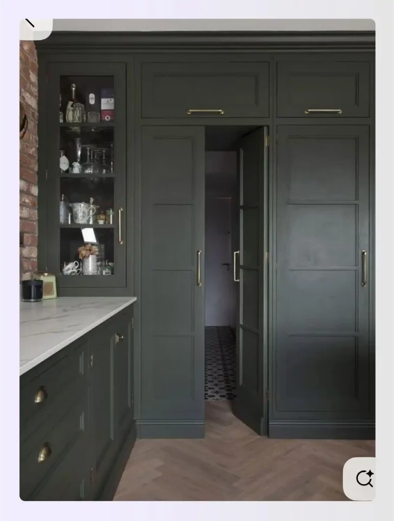 Dark green pantry cabinets with one section acting as a hidden door