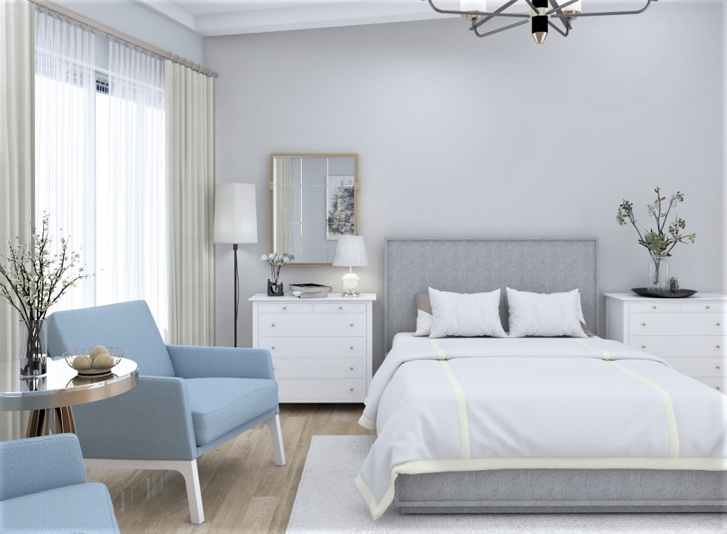 Bright and airy guest room with a comfortable seating area and a bed.