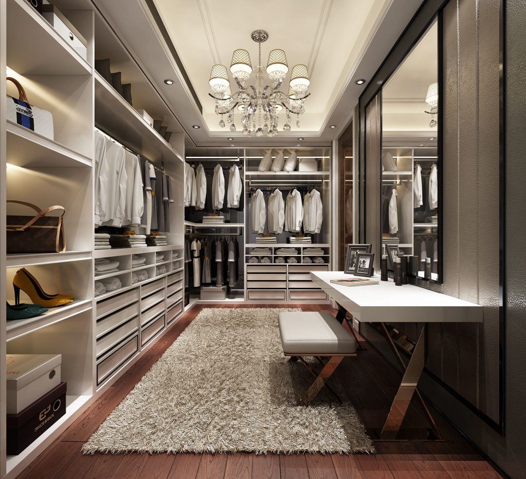 Walk-in closet with clothes hanging on racks and shelves.