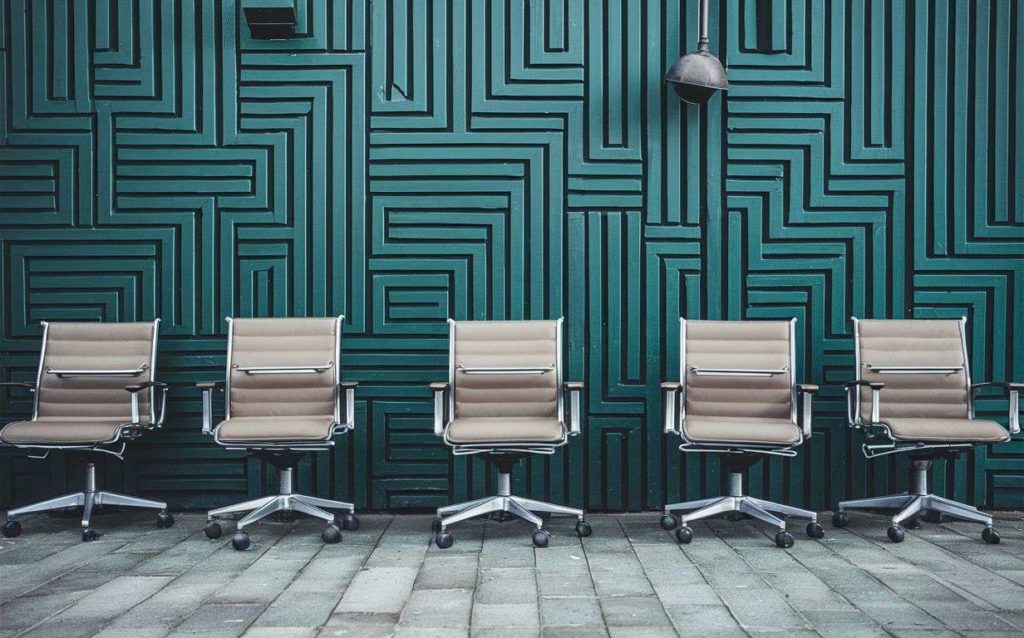 Office chairs in front of green wall