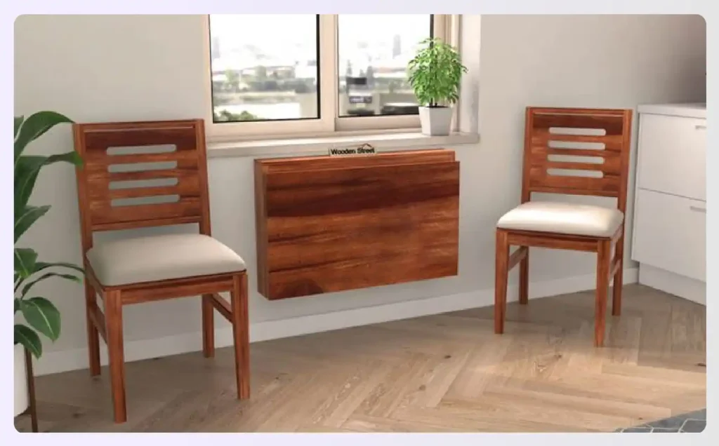 A foldable wooden dining table and chairs mounted on a wall