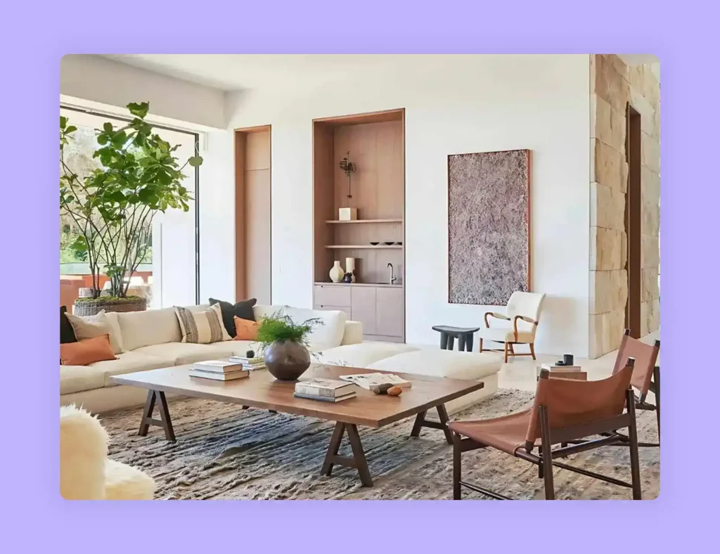 A living room with a large neutral sofa, wooden coffee table, and natural light.