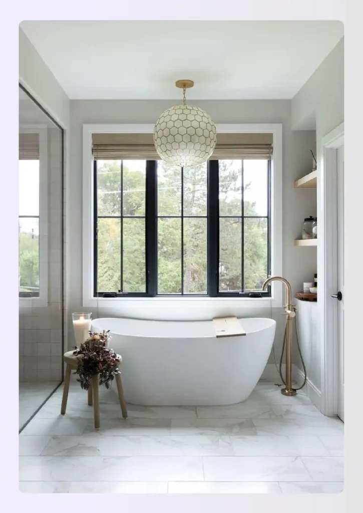 Freestanding soaking tub centred beneath a large picture window Freestanding soaking tub centred beneath a large picture window